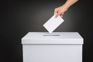 The voter holds his vote ballot paper and places it in the ballo